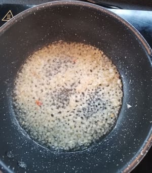 Eine Bratpfanne vorbereiten, das Öl hineingeben, warten bis es heiß ist, dann den Knoblauch hinzufügen und umrühren, bis es duftet.