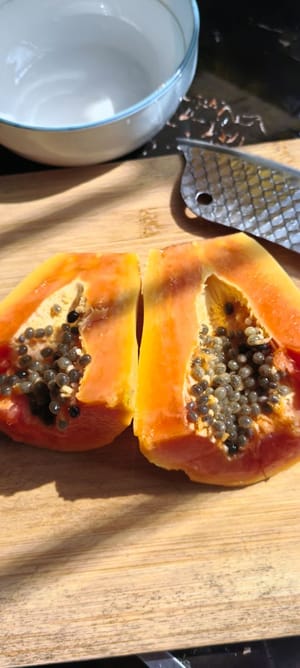Die Papaya schälen und halbieren.