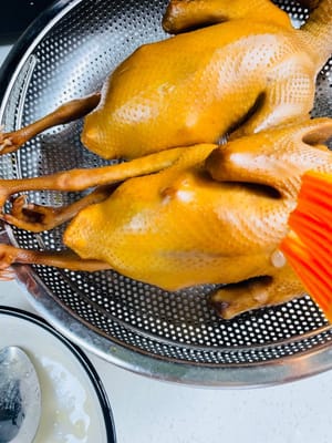 Retirez le pigeon de la saumure, égouttez-le et badigeonnez-le de vinaigre blanc. Laissez-le sécher à l'air libre pendant une demi-heure, puis badigeonnez-le d'eau de miel.
