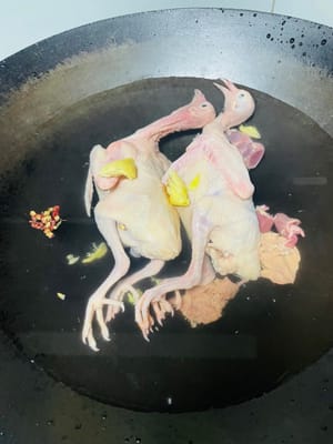 處理乳鴿
把乳鴿裡裡外外都清洗乾淨，然後冷水下鍋，放入料酒、花椒、薑片進行焯水，汆燙後洗乾淨並瀝乾水分備用。