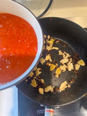 จากนั้นเทซอสมะเขือเทศที่เตรียมไว้และซุปเปรี้ยวแดงสูตรพิเศษของกุ้ยโจวลงไป