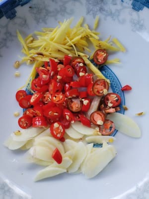 Cut the chili pepper, shred the ginger, slice the garlic and place on a plate for later use.