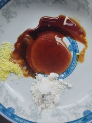 Put one spoon of oyster sauce, 1/2 spoon of light soy sauce, one spoon of starch and one teaspoon of chicken stock on a plate.