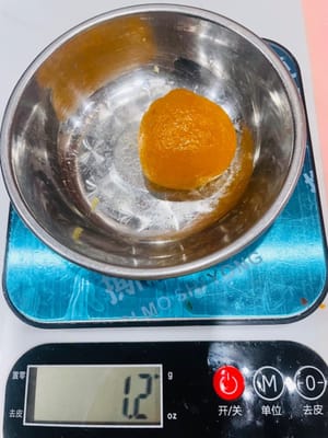 Dividere il ripieno e la base. Per mooncake da 50 grammi ciascuno, utilizzare un rapporto 1:1 tra la base e il ripieno. Per prima cosa, dividere il ripieno in piccole palline del peso di circa 25 grammi ciascuna. Arrotolare fino a formare delle palline rotonde e mettere da parte.