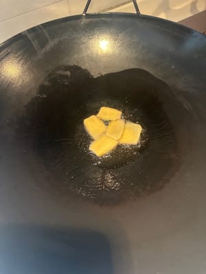 将鱼头清洗干净，擦干水。锅子烧热，放油，放姜片翻煎两下，下鱼头翻煎两面。煎少许金黄色下料酒。去腥味。