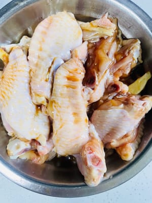 Ajoutez 1,5 cuillère à soupe de sauce soja, 1 cuillère à soupe de vin de cuisine, 1 cuillère à soupe de sauce aux huîtres, 1 cuillère à café de poivre blanc, 1 cuillère à café de sel et du gingembre râpé aux ailes de poulet après les avoir égouttées. Bien mélanger et laisser les ailes de poulet s'imprégner des saveurs de ces assaisonnements. Laissez mariner plus d'une demi-heure. Vous pouvez les laisser reposer tranquillement pendant ce temps.