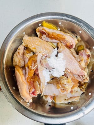 Égouttez les ailes de poulet marinées, puis contrôlez l'eau, ajoutez une petite cuillère de fécule de maïs et mélangez uniformément. Cette étape permet de rendre les ailes de poulet encore plus savoureuses une fois frites.