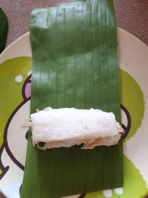 用香蕉葉包裹，然後像這樣捲起嚟。包裹直到麵團用完。
