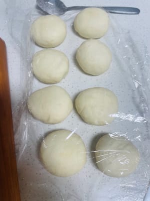 Divide the dough into small pieces and let them rise: Sprinkle flour on the work surface, take out the dough and divide it into small pieces of about 45g, roll them into balls, cover with plastic wrap, and let them rise for 15 minutes to let the small pieces of dough