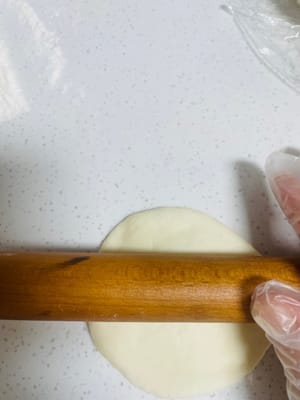 Prendi un impasto, stendilo e poi stendilo con un mattarello in una forma rotonda, come se stessi 