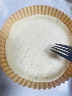 Shaping 2: Flatten and shape it to fit perfectly with the pizza tray. Finally, use a fork to poke small holes in the dough to prevent it from