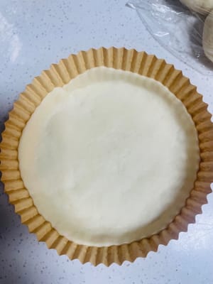 Take a dough, flatten it, and then roll it into a round shape with a rolling pin, like