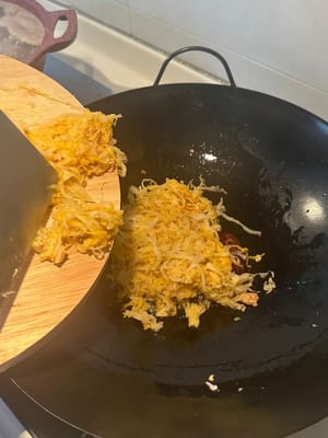 加入瀝乾的酸菜，繼續煎炒，直到開始變乾