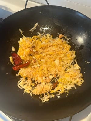 加入瀝乾的酸菜，繼續煎炒，直到開始變乾