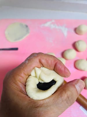 Nehmen Sie ein Stück Teig, rollen Sie es zu einer dünnen Scheibe aus, füllen Sie es mit roter Bohnenpaste, verschließen Sie es mit dem Tigermaul und drücken Sie es dann zum Braten flach.