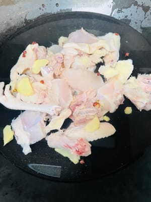Hähnchen waschen, in einen Topf mit kaltem Wasser geben, 1 EL Kochwein, Ingwerscheiben, Pfefferkörner (oder Frühlingszwiebeln) zugeben, kochen, Schaum abschöpfen, herausnehmen und mit warmem Wasser abspülen.