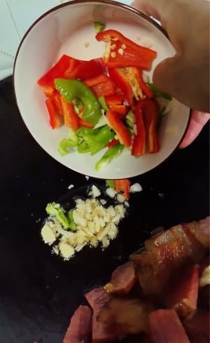 Heat the pan, fry the bacon first to remove excess oil, set the bacon aside, or put it on a plate, then add garlic, ginger, chili salt and fry for 1 minute