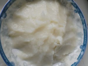 Zwei Löffel Zucker zur gedämpften Yamswurzel geben, mit einem Löffel zerdrücken und beiseite stellen.