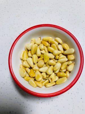 Jika kacang pinus masih mentah, masukkan ke dalam wajan tanpa minyak dan tumis perlahan dengan api kecil hingga sedikit menguning. Jangan sampai gosong karena akan menjadi pahit.