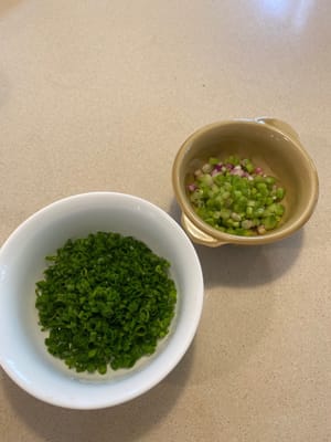 Émincer finement les oignons verts, en séparant le blanc du vert. Hacher finement les gousses d'ail. Émincer finement les piments, si vous en utilisez.