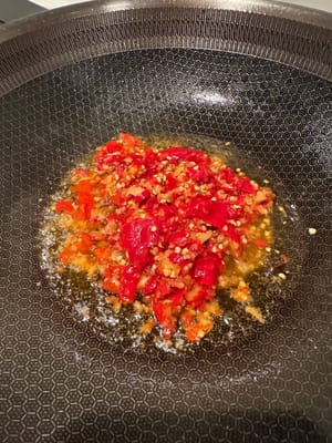 Di wajan lain yang sudah dipanaskan dengan minyak, mulai tumis minyak cabai fermentasi hingga harum.