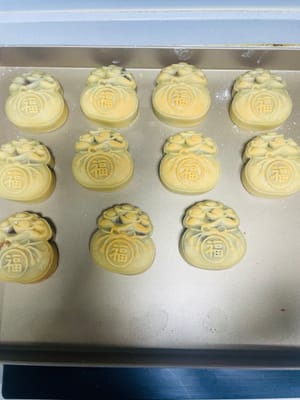 6. Baking the Mooncakes
1. Preheat the oven to 200°C. Spray the mooncakes with water before placing them in the oven. Bake them in the middle rack for 5 minutes to set.
2. Remove the mooncakes and wait for the temperature to drop to around 70-80°C. Then, lightly brush the mooncakes with the egg wash you prepared earlier. Be careful not to overdo it, as it will lose the texture. (Use this type of brush, not a silicone one.)
3. Reduce the oven temperature to 160°C. After brushing with the egg wash, return the mooncakes to 160°C and bake for 8-10 minutes. Keep an eye on them to ensure they don't burn.