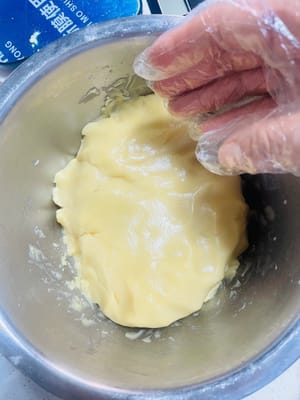 다음으로, 중력분 320g을 넣고 손으로 가루가 없어질 때까지 섞습니다. 그릇을 비닐 랩으로 덮고 반죽을 실온에서 2시간 동안 휴지시킵니다. 반죽을 충분히 휴지시키지 않으면 구울 때 갈라지고, 너무 오래 휴지시키면 반죽이 꺼질 수 있으니, 적절한 균형을 맞추는 것이 중요합니다.