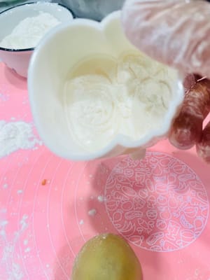 First, sprinkle some dry flour inside the mooncake mold to prevent sticking.
Place the wrapped mooncake balls on a baking sheet, carefully covering them with the mooncake mold. Hold the mold firmly with your hand and press down gently. The beautiful mooncake dough will emerge.