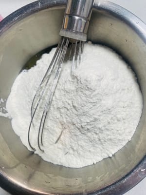 Next, add 320g of all-purpose flour and mix with your hands until no dry powder remains. Cover the bowl with plastic wrap and let the dough rest at room temperature for two hours. Remember, if the dough isn't rested enough, it will crack when baked, and if it's rested too long, it will collapse. It's crucial to strike the right balance.