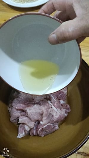 add 3g salt, 1g pepper, 1 egg white, 1 spoon of cooking wine to the sliced meat. Add a little starch and mix well. Marinate for 5 minutes, then pour cooking oil on it and stir. This will make the meat more tender and smooth.