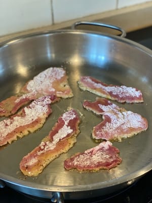 Añade 1 cucharada de aceite a una sartén a fuego medio-alto. Una vez caliente, añade las lonchas de cerdo y cocina durante 1 o 2 minutos hasta que estén ligeramente doradas.