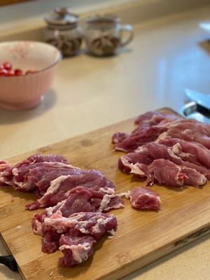 Cortar la carne de cerdo en rodajas finas
