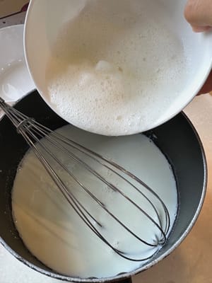 Anschließend das Eiweiß unter ständigem Rühren in die abgekühlte Milch geben.