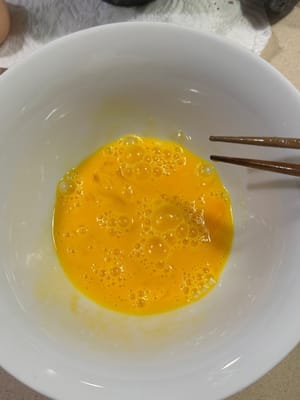 Dans un bol, fouettez l'œuf et ajoutez les calamars assaisonnés. Assurez-vous qu'ils soient bien incorporés.
