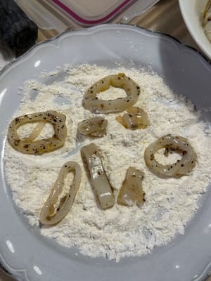 Enrober les calamars de farine, tapoter délicatement pour enlever l'excédent de farine et les placer sur une assiette propre pour les faire frire