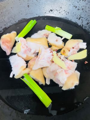 Boil the pig's feet skin clean, wash and cut into large pieces, put pepper, green onion, cooking wine and ginger into a pot under cold water, blanch for 5 minutes, wash and drain.