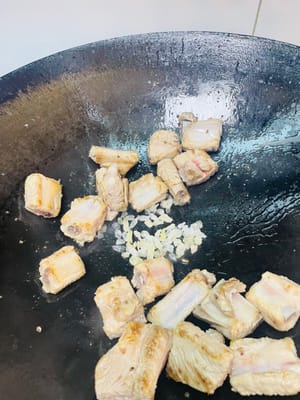 Fry and color: Grease the pan with oil to prevent sticking. Add the spareribs and fry until both sides are golden brown. Add yellow rock sugar and fry until the sugar color comes out, giving the spareribs an attractive color and a caramelized aroma.