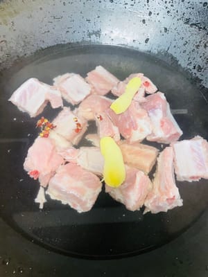 Coupez les travers de porc en gros morceaux pour qu'ils soient plus faciles à manger, lavez-les, versez de l'eau froide dans la marmite, ajoutez les grains de poivre/oignons verts et les tranches de gingembre, blanchissez-les, lavez-les, égouttez-les et réservez.