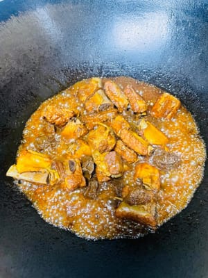After the pressure in the pressure cooker has naturally dropped, open the lid and pour the sauce back into the wok. Cook over high heat until the sauce is thick enough to coat the pork ribs. Then serve.