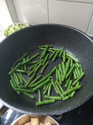 Faire revenir les haricots longs à moitié cuits et retirer du feu