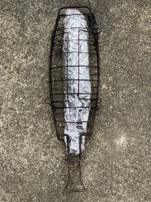 Coloque el pescado envuelto en la rejilla para pescado.