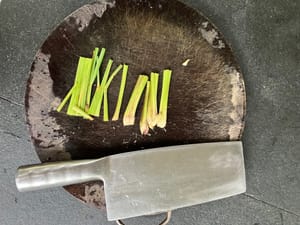 Machacar la hierba limón con el dorso de un cuchillo para liberar la fragancia.