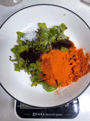 炒辣椒(川渝暴龍的進化秘技!)
鍋燒乾別放油,直接把青辣椒倒進去乾煸!炒到水分全收乾、辣椒起皺、微微發焦,這時候的辣椒香到離譜!然後加食用油、2g鹽翻勻盛出來。
再放10g辣椒粉、8g蠔油,拌勻備用!
(這步就是「川渝暴龍」的養成核心!誰也不是天生就會噴火的暴龍,全靠這青辣椒+辣椒粉的雙重辣度buff疊滿!能吃辣的直接拉滿,吃完直接進化成川渝暴龍,噴火都不在話下;