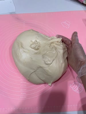 排氣鬆弛:發好的麵團拿出來,輕輕拍扁排氣,
以你想要的大小分割(我做了配方3倍量,用其中三分一的量來做辣麵包。
蓋保鮮膜鬆弛15分鐘,讓麵團歇會兒,不然擀不開!