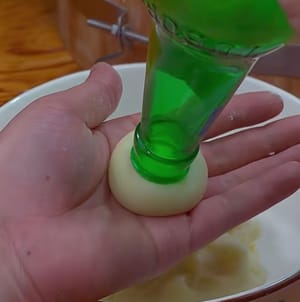 Luego, haz bolitas pequeñas y luego utiliza una botella de vino para darle forma de hongo.