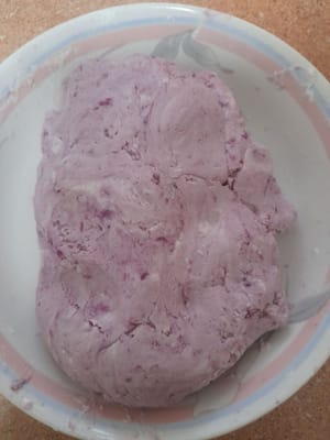 Verter 200 ml de leche de coco (100 ml de agua tibia, mezclar con la leche de coco y remover) poco a poco, amasando hasta que la masa esté suave y se pueda extender. Tomar un poco de masa y formar una bola.