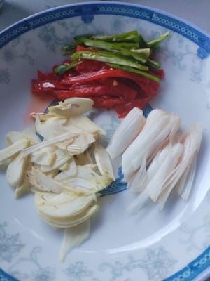 Cortar el ajo en láminas, los brotes de ajo y los pimientos verdes y rojos en tiras y reservar.