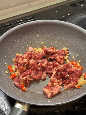 Rindfleisch hinzufügen und unter Rühren braten, bis das Rindfleisch braun wird