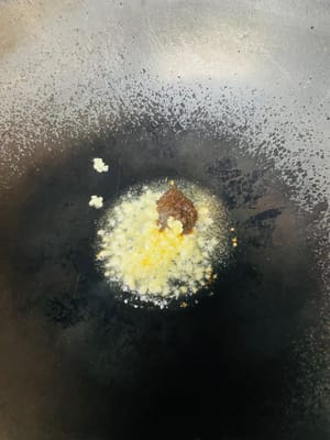 锅中放油,烧热后稍凉关火,趁热加入1汤匙郫县豆瓣(因郫县豆瓣偏咸,切勿加太多),再加入蒜蓉炒出红油和蒜香,倒入腌好的肉类中拌匀。