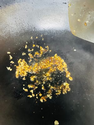 锅中放油,烧热后稍凉关火,趁热加入1汤匙郫县豆瓣(因郫县豆瓣偏咸,切勿加太多),再加入蒜蓉炒出红油和蒜香,倒入腌好的肉类中拌匀。